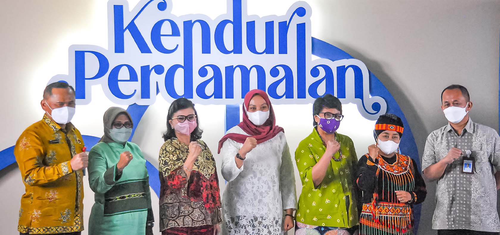 Representatives of Indonesian ministries, UN Women Indonesia and local organization AMAN gesture to indicate their determination to “build back better by protecting and empowering women and girls in social conflict” in line with the theme of the event, in front of a sign reading “Peace Festival”. Photo: UN Women